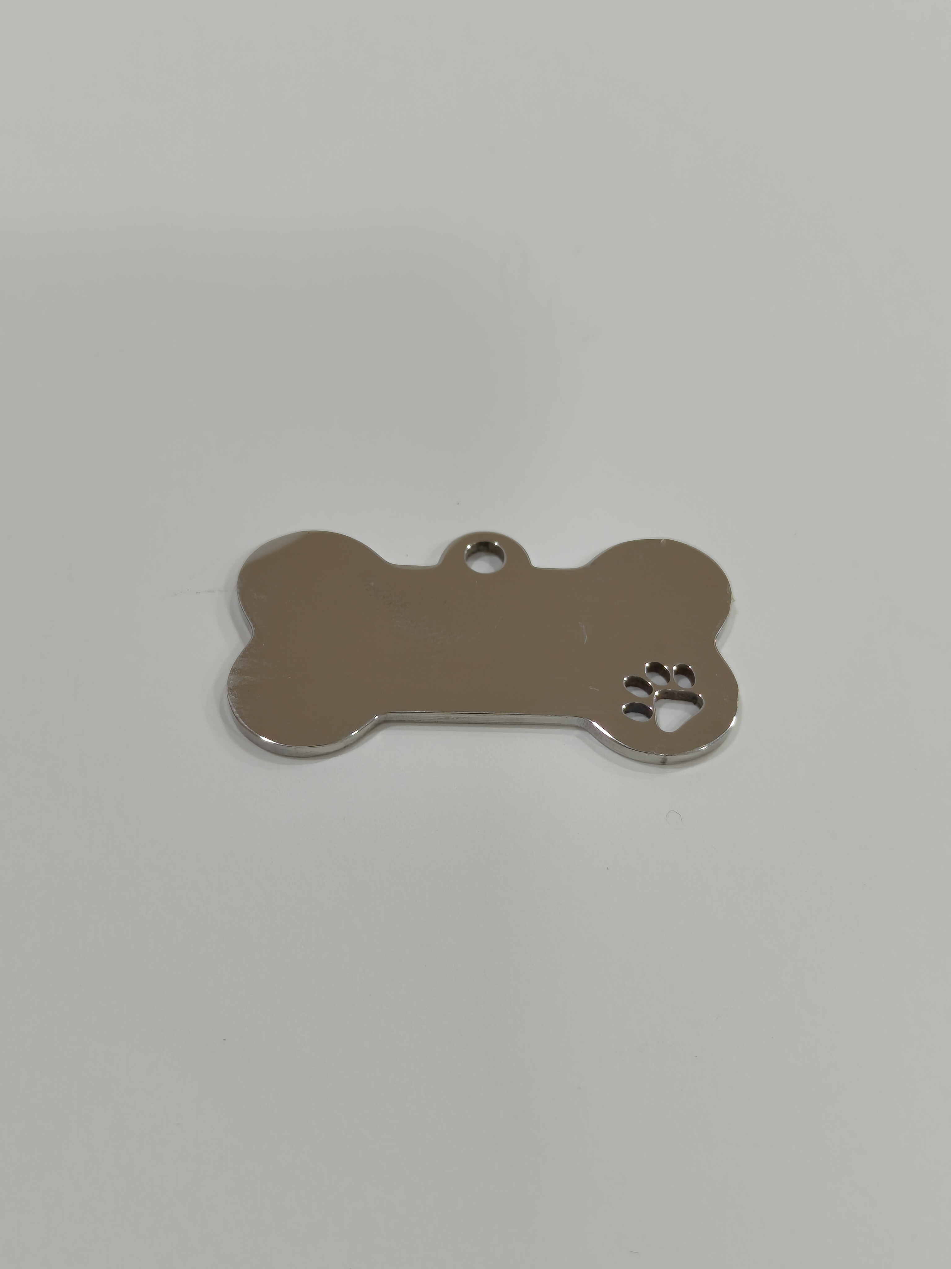 Placa de identificação para animais com ilustração de pata e dados gravados a laser